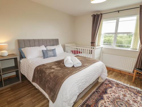 a bedroom with a bed with a crib and a window at The Sperrin Getaway in Omagh