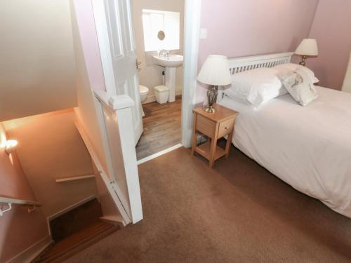a small bedroom with a bed and a sink at Ewe Cottage in Ripon