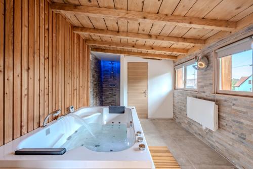 a large bath tub in a room with wooden walls at RIESLING - Vue imprenable sur le vignoble - rénové récemment - parking gratuit in Riquewihr