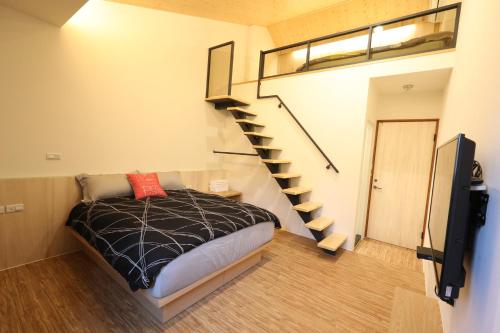 a bedroom with a bed and a spiral staircase at 舒室民宿 in Tainan