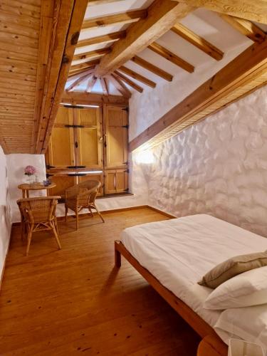 a bedroom with a bed and a table with chairs at Casa Aldea l'Ayalga in Beloncio