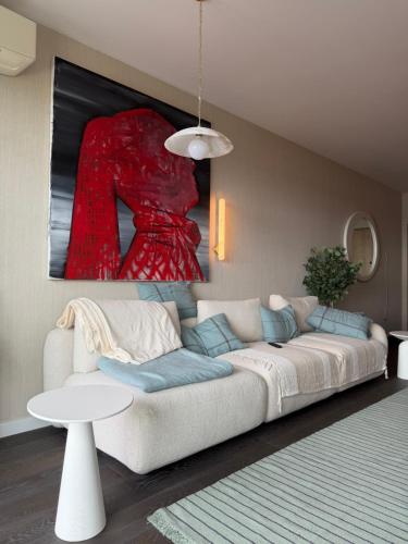 a living room with a white couch and a painting at ViP PRATUM in Mikołajki