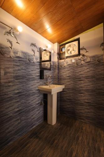 a bathroom with a sink and a wall at लेक एंड वुड्स in Bhīm Tāl