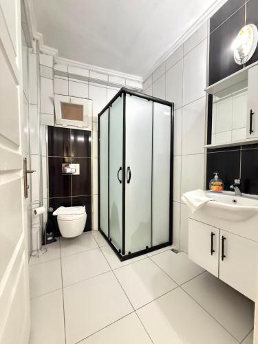 a bathroom with a toilet and a glass door at KAŞ MERKEZ İMREN APART 2 in Kaş