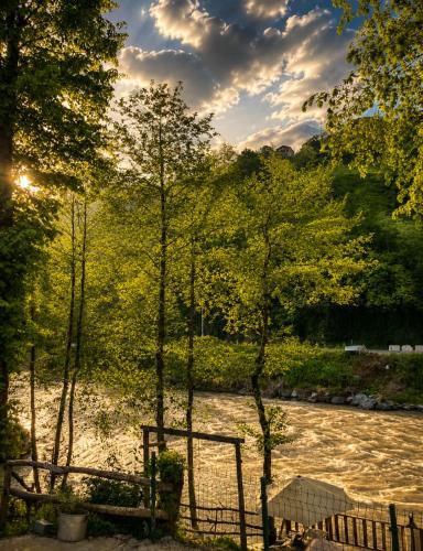 a bench next to a river with a fence at MOLVA Bungalows Otel in Çamlıhemşin