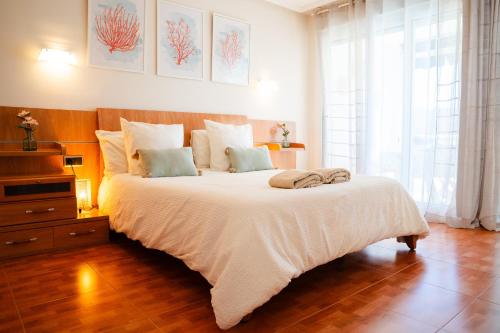 a bedroom with a large bed with white sheets at El BALCON DE BAKIO in Bakio