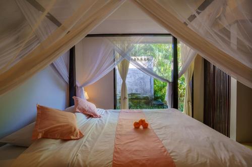 a bedroom with a bed with a large window at Villa Seaview- tranquil 3BR, beachfront, private pool in Bukti