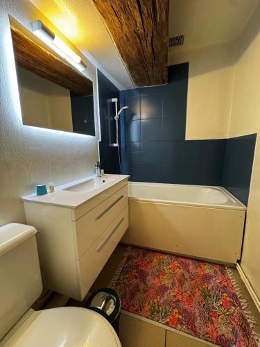 a bathroom with a sink and a tub and a toilet at Ancien hôtel du Thaurion in Saint-Hilaire-le-Château