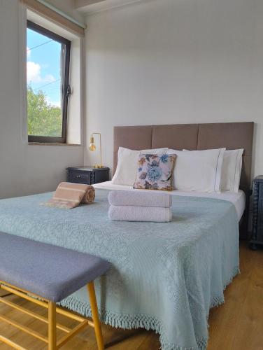a bedroom with a large bed with towels on it at Casa do Largo do Cruzeiro in Vouzela