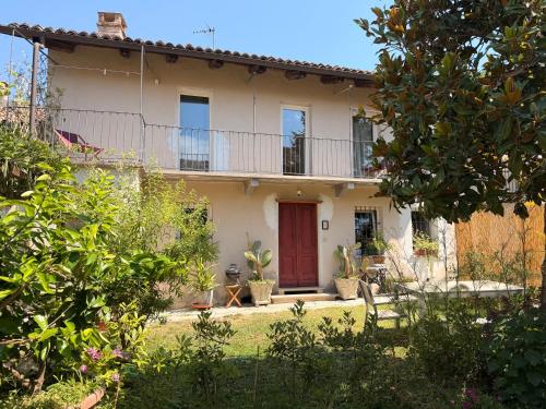 a house with a red door in a garden at Kiki's Langhe House in Castagnole Lanze