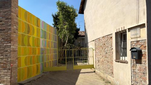 a gate to a building with a colorful wall at Kiki's Langhe House in Castagnole Lanze