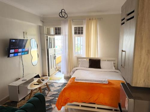a bedroom with a bed with an orange blanket at Tulivu Homes in Meru