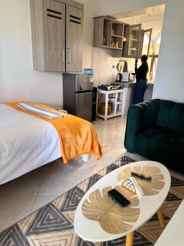 a room with a bed and a table and a couch at Tulivu Homes in Meru