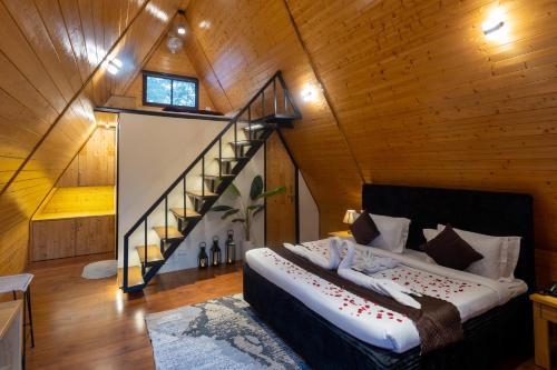 a bedroom with a bed and a staircase in a room at The Arks Baagh Villas in Rāmnagar