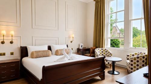 a bedroom with a bed and a chair and a window at No32 Hotel in Edinburgh