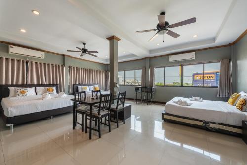 a bedroom with two beds and a table and chairs at BKK39 Airport Hotel in Lat Krabang
