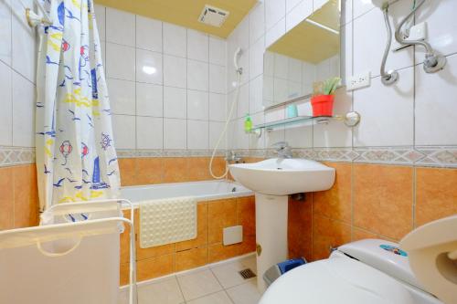 a bathroom with a sink and a toilet and a tub at CT Theme Suite in Kaohsiung