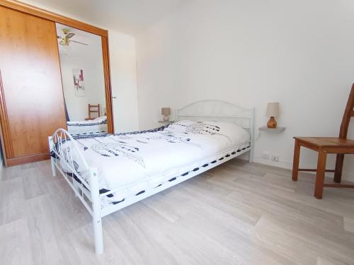 a white bed in a room with a mirror at APPARTEMENT à 5 mn de la plage in Saint-Hilaire-de-Riez