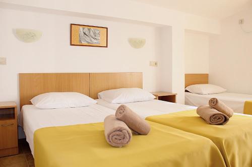 zwei Betten in einem Zimmer mit Handtüchern darauf in der Unterkunft Hotel Radik in Sozopol