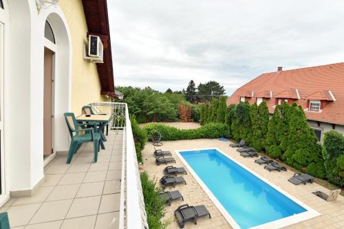 a balcony with a swimming pool and a table and chairs at Royal Villa in Balatonfüred
