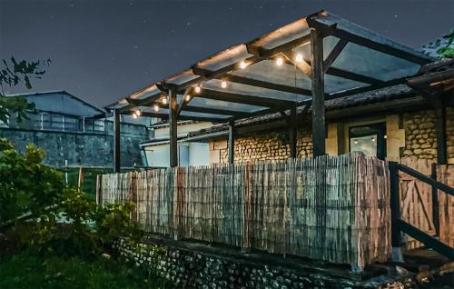 a pergola with lights on a house at night at Harmant Gîte Au Calme in Saint-Maigrin