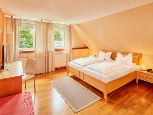 a bedroom with a bed with white sheets and pillows at Püttmanns Dorfhotel in Olpe