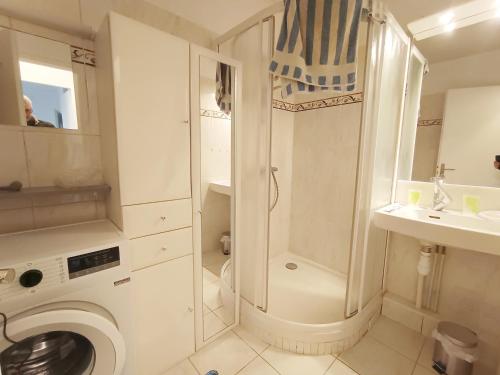 a white bathroom with a shower and a washing machine at APPARTEMENT à 5 mn de la plage in Saint-Hilaire-de-Riez
