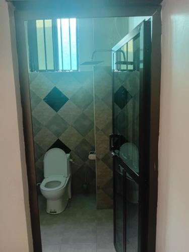 a bathroom with a toilet and a glass shower at Ponte Vedra Lodge in Mwanza