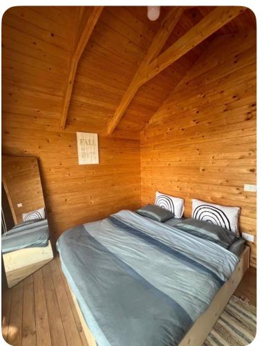 a bedroom with a bed in a wooden room at Rickystone in Jiwār al Bawāshiq