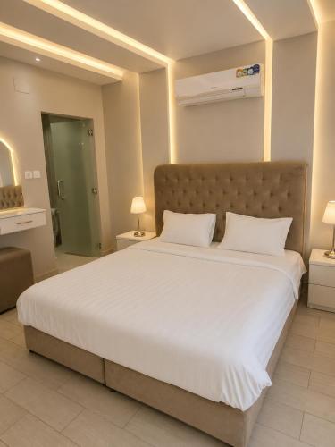 a bedroom with a large bed with white sheets at منتجع الفيا - مسابح in Abha