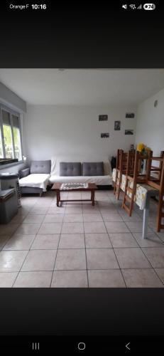 a living room with a couch and a table at Chez Bernard in Mareuil-Caubert