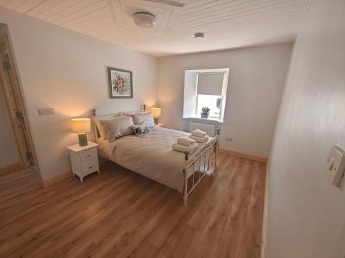 a bedroom with a bed and a window at Maggies Cottage in Manorhamilton