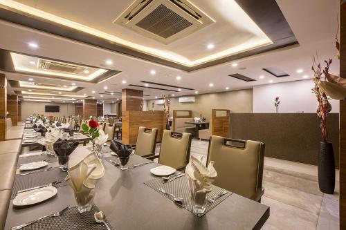 uma sala de jantar com uma mesa longa e cadeiras em Prominent Corporate Residency em Gandhinagar