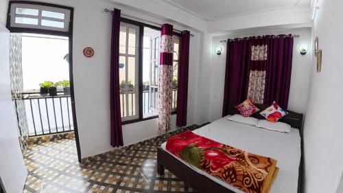 a bedroom with a bed and a balcony at Nini's Homestay, Kalimpong in Pedong