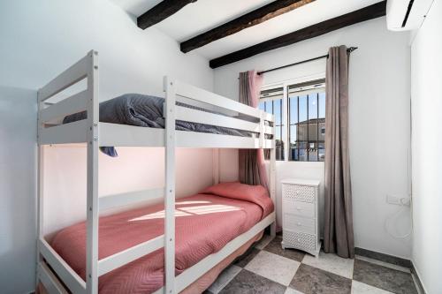 a bedroom with two bunk beds and a window at VillaHaba BarrosaHome in Novo Sancti Petri