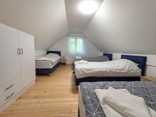 a attic room with three beds and a room with at Vila Vidovic Drina in Bajina Bašta