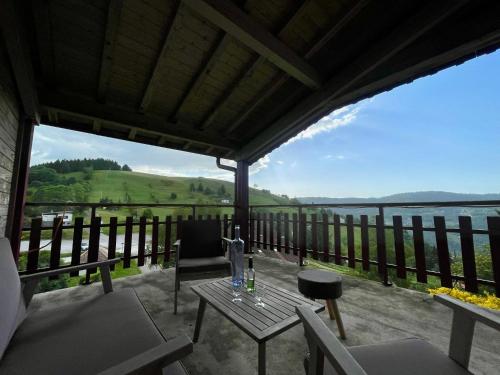 a patio with a table and chairs and a view of the water at Gîtes BEL'M in La Bresse