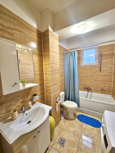 a bathroom with a sink and a toilet and a tub at Summerland Seaview Premium Apartments in Mamaia