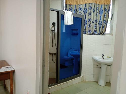 a bathroom with a blue shower and a toilet at Abuesi Beach Resort in Sekondi-Takoradi