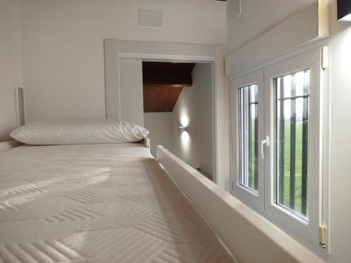 a white bedroom with a bed and a window at Sweet November in Valencia