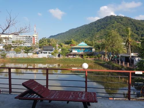 a wooden bench sitting next to a body of water at Delight Resort in Haad Rin