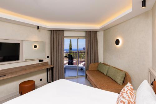 a hotel room with a bed and a couch and a television at SİDE SUN in Manavgat