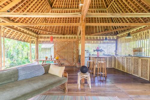 a large living room with a couch and a bar at Cosy Cottage Living Harmoniously in Tabanan