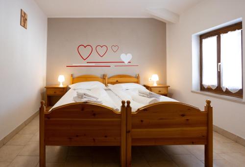 a bedroom with a bed with two hearts on the wall at Santa Maria ad Nives in Canazei