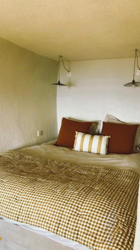ein Schlafzimmer mit einem großen Bett und drei Kissen in der Unterkunft Cap Hélios, vue mer à couper le souffle à Centuri in Morsiglia