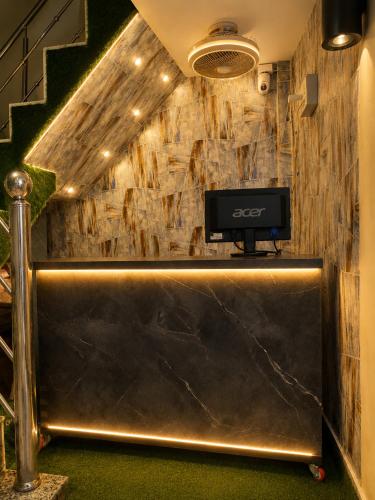 a reception desk with a tv on a wall at Elora Hotel in Ujjain