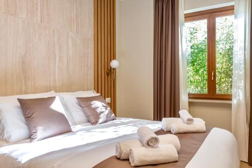 a bedroom with a bed with towels on it at Guest House Aura - Lumys Fiumicino in Fiumicino