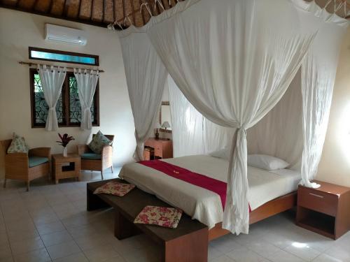 a bedroom with a bed with a canopy at Sang Fajar Ubud in Ubud