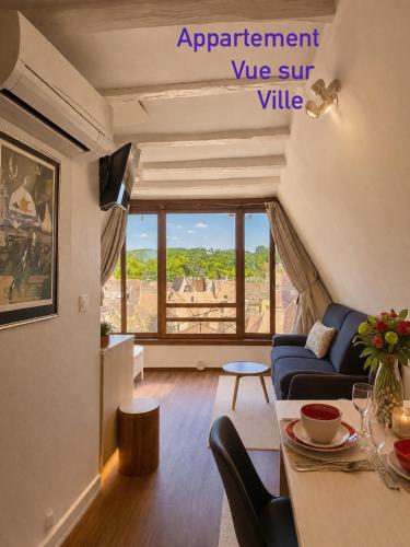 a living room with a couch and a table at FRANRÉAL, 4 Appartements Climatisés in Sarlat-la-Canéda