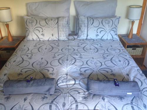un letto con due cuscini sopra e due tavoli di Nibelheim Self Catering Cottage a Hogsback
